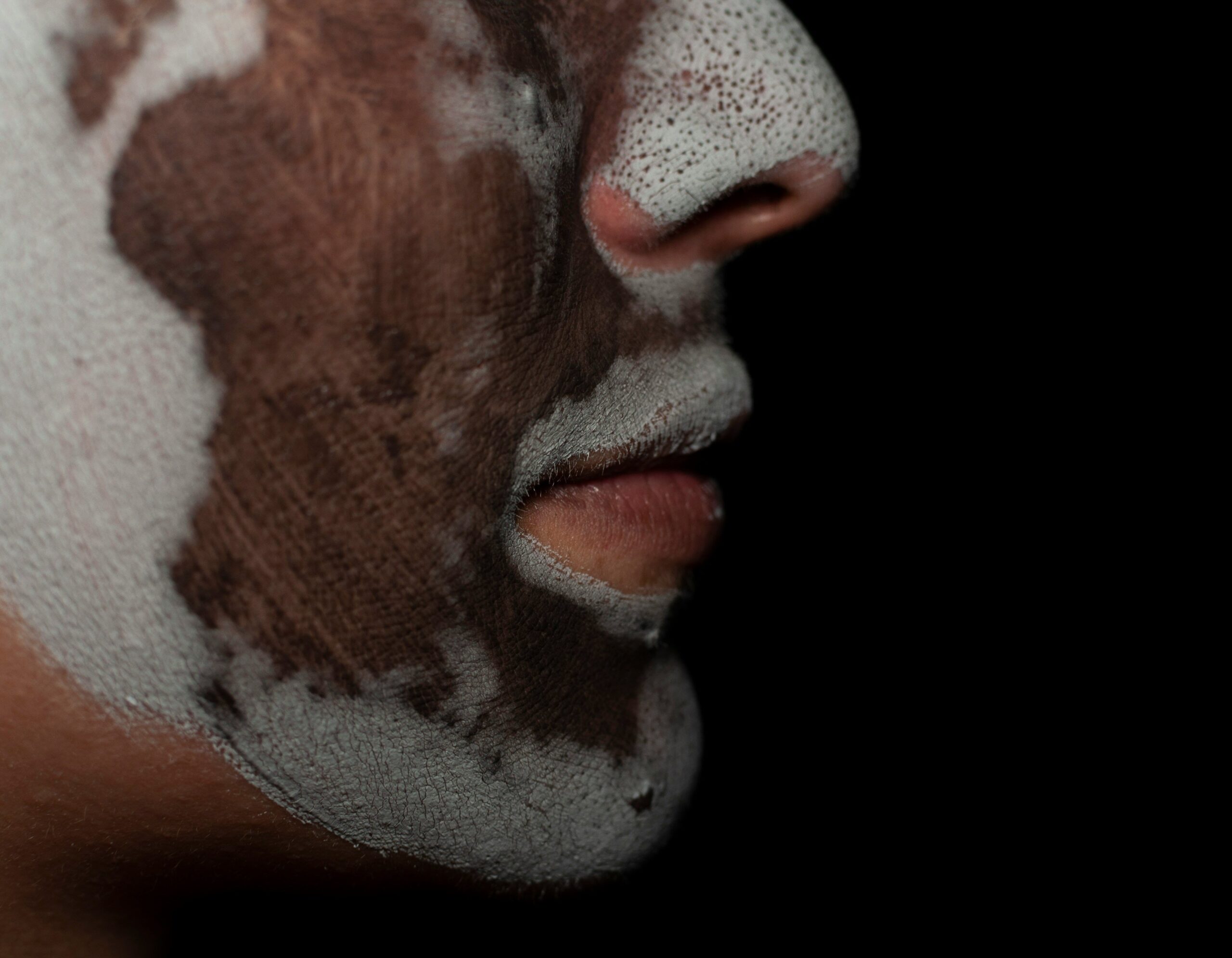 Person applying moisturizer after cleansing and toning at night