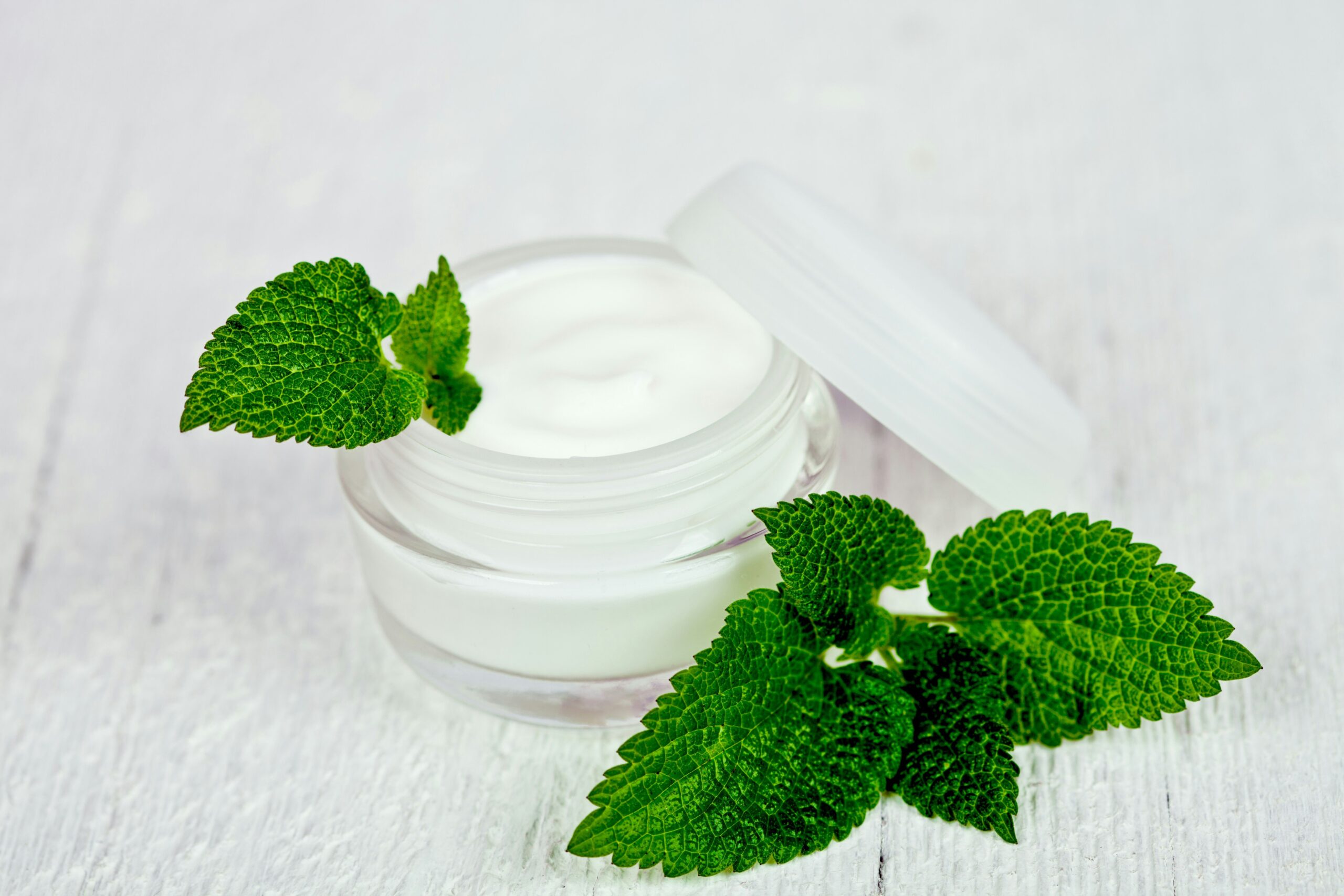 Person gently massaging herbal hydration balm onto their cheeks