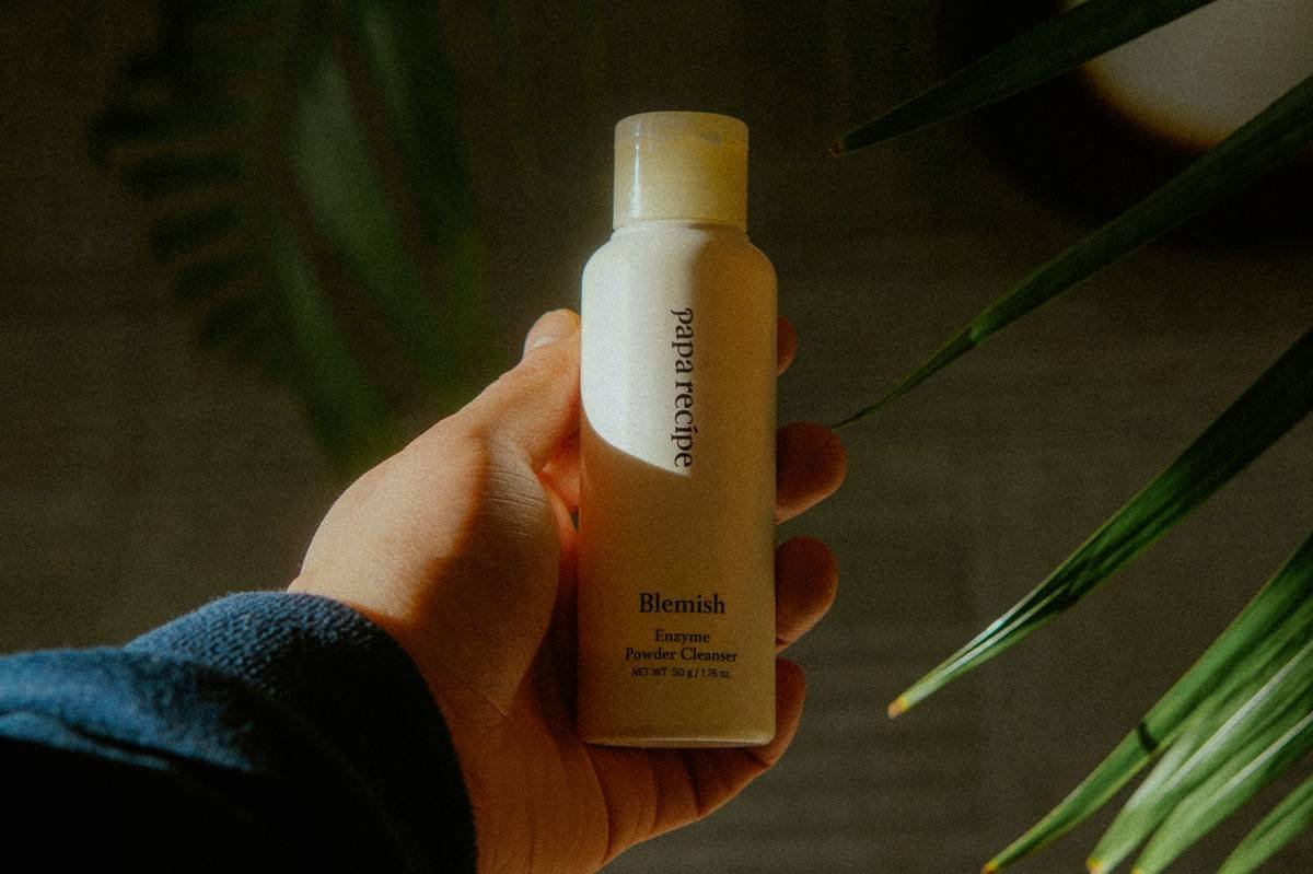 A person holding a bottle of lotion in their hand