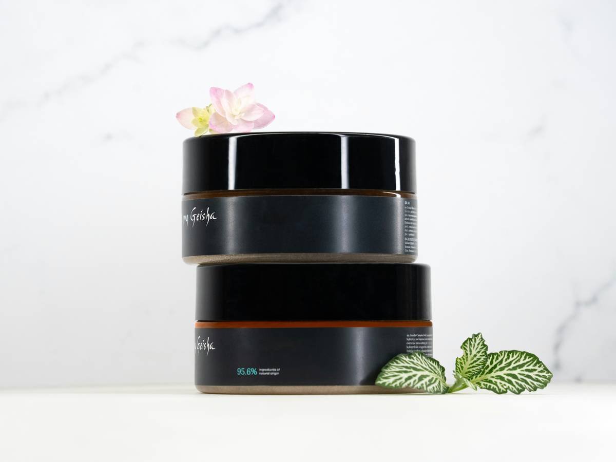Two cosmetic jars stacked with plants and plants